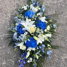Blue and white casket including lilies